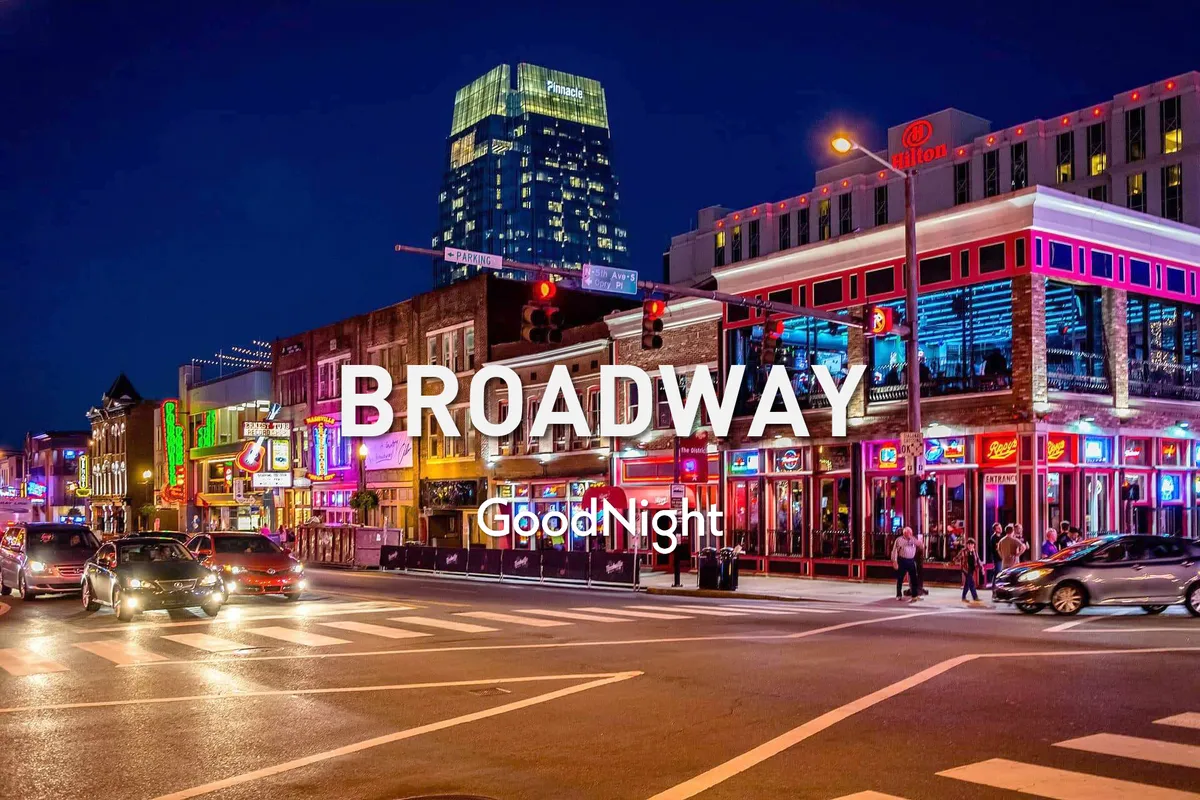 This exterior image captures a bustling Nashville street at night, illuminated by bright neon signs and filled with energetic street activity. Various storefronts and the Hilton hotel can be seen, suggesting an area rich with nightlife, dining, and live music venues.
